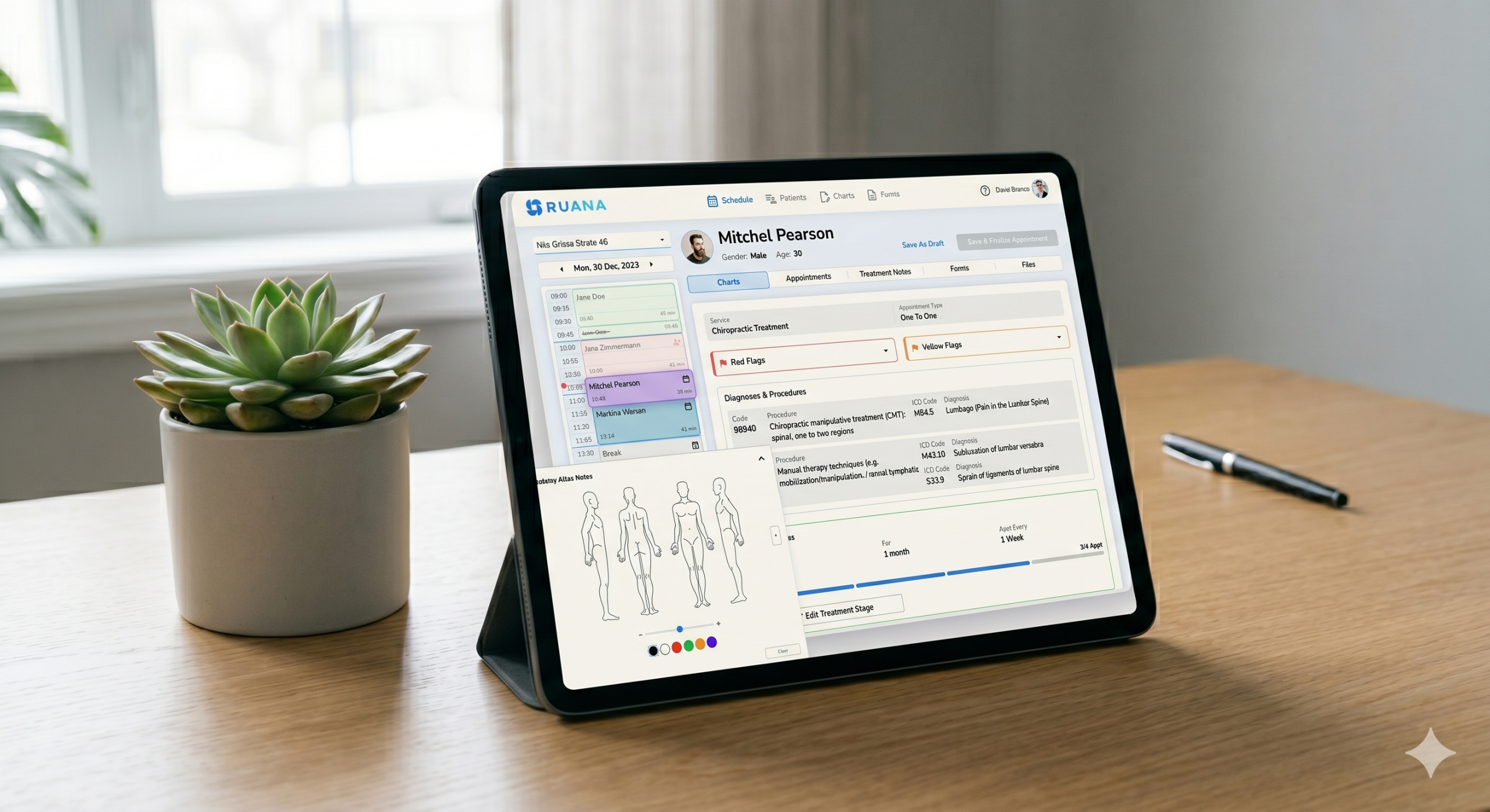 Primer plano de una tablet sobre un escritorio de madera con una interfaz de software de historia clínica para osteopatía. Se muestra el panel de control del paciente Mitchel Pearson, incluyendo calendario de citas, códigos de diagnóstico y un gráfico anatómico para notas de tratamiento. Al lado hay una pequeña planta suculenta en una maceta blanca bajo una luz natural suave.